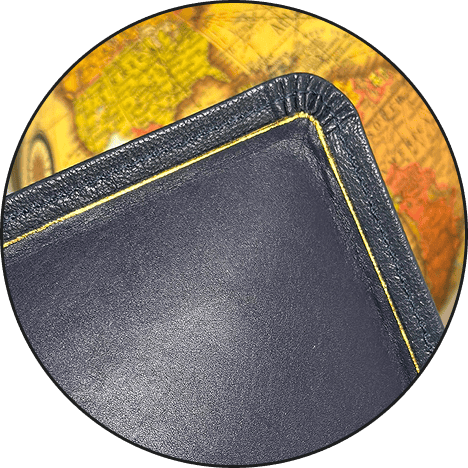 Close-up of a black leather wallet with yellow stitching on a colorful map background.